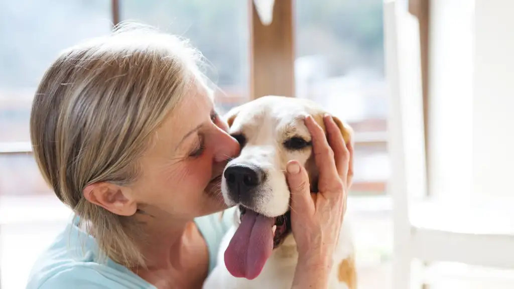 Woman kissing her dog
